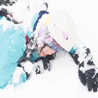 雪山で滑落したヘルメット着用の女性登山者の写真