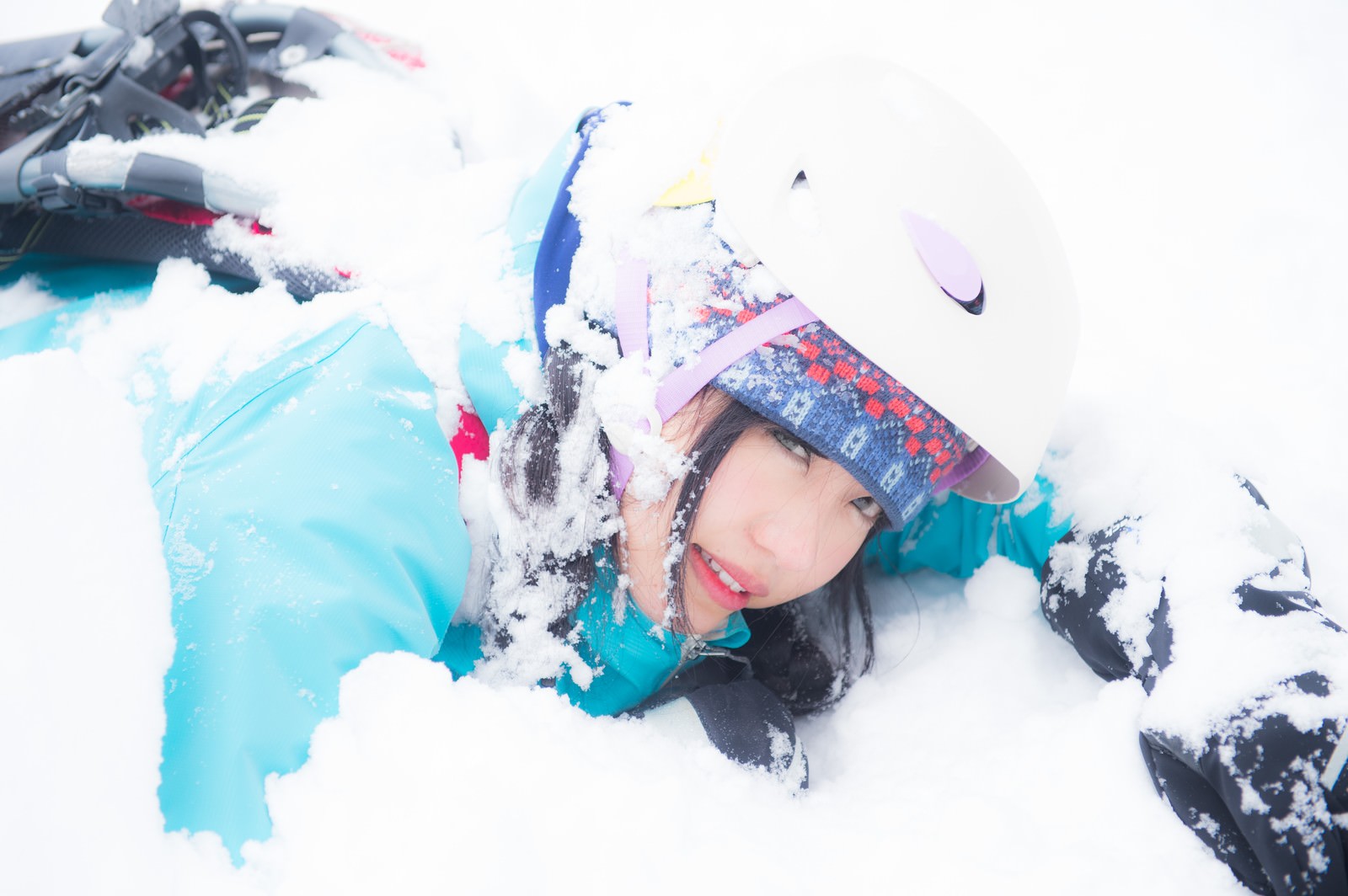 落雪を受けて雪上に倒れたスノーシュー姿の登山者［モデル：河村友歌］