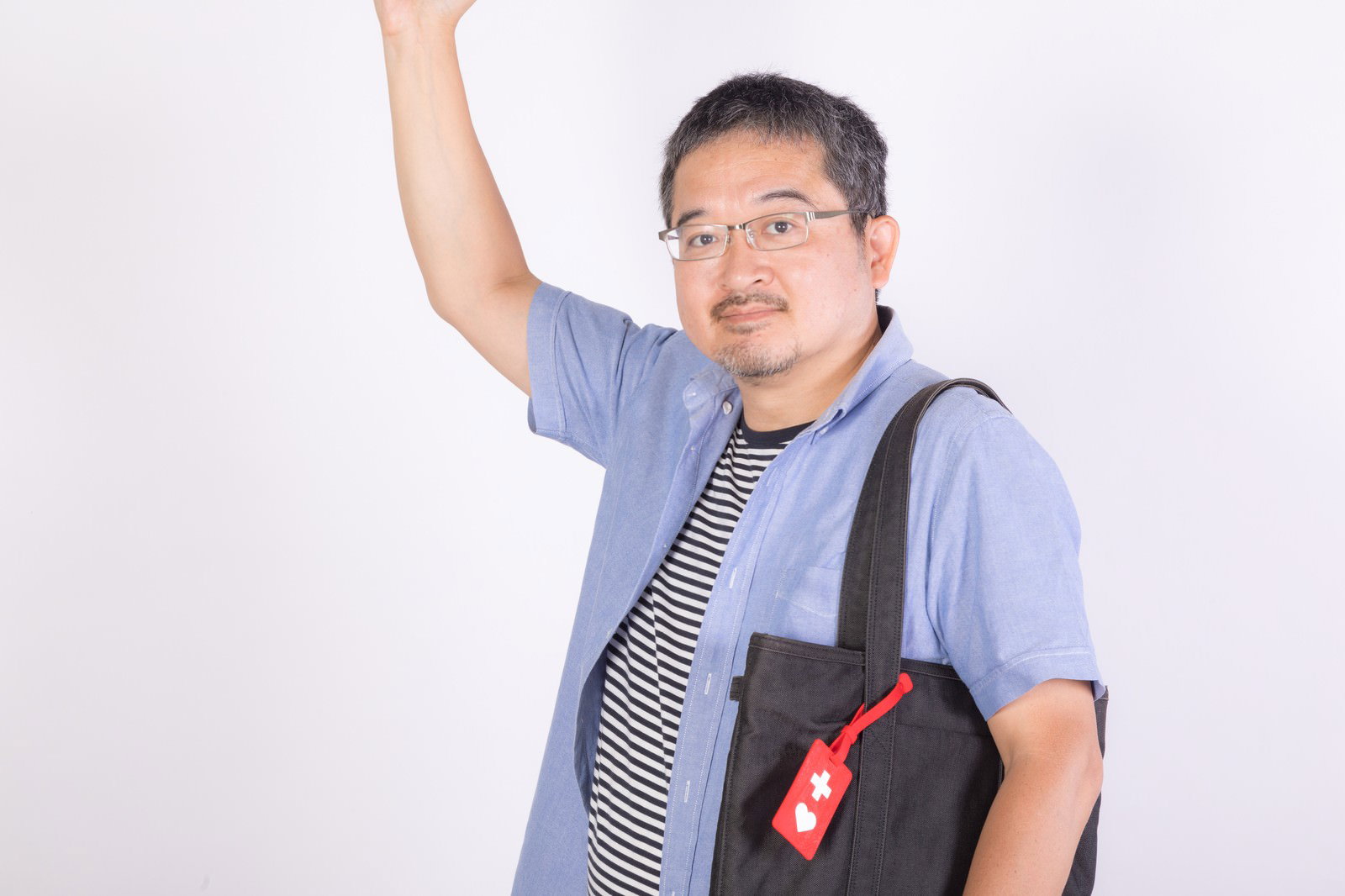 ヘルプマークを付けたエコバッグを持つ男性［モデル：ナリシゲ］