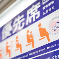 電車内の優先席に掲示されたマタニティマークとヘルプマークの写真