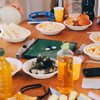 ホームパーティーのテーブルに並ぶお菓子や食べ物とゲームの写真