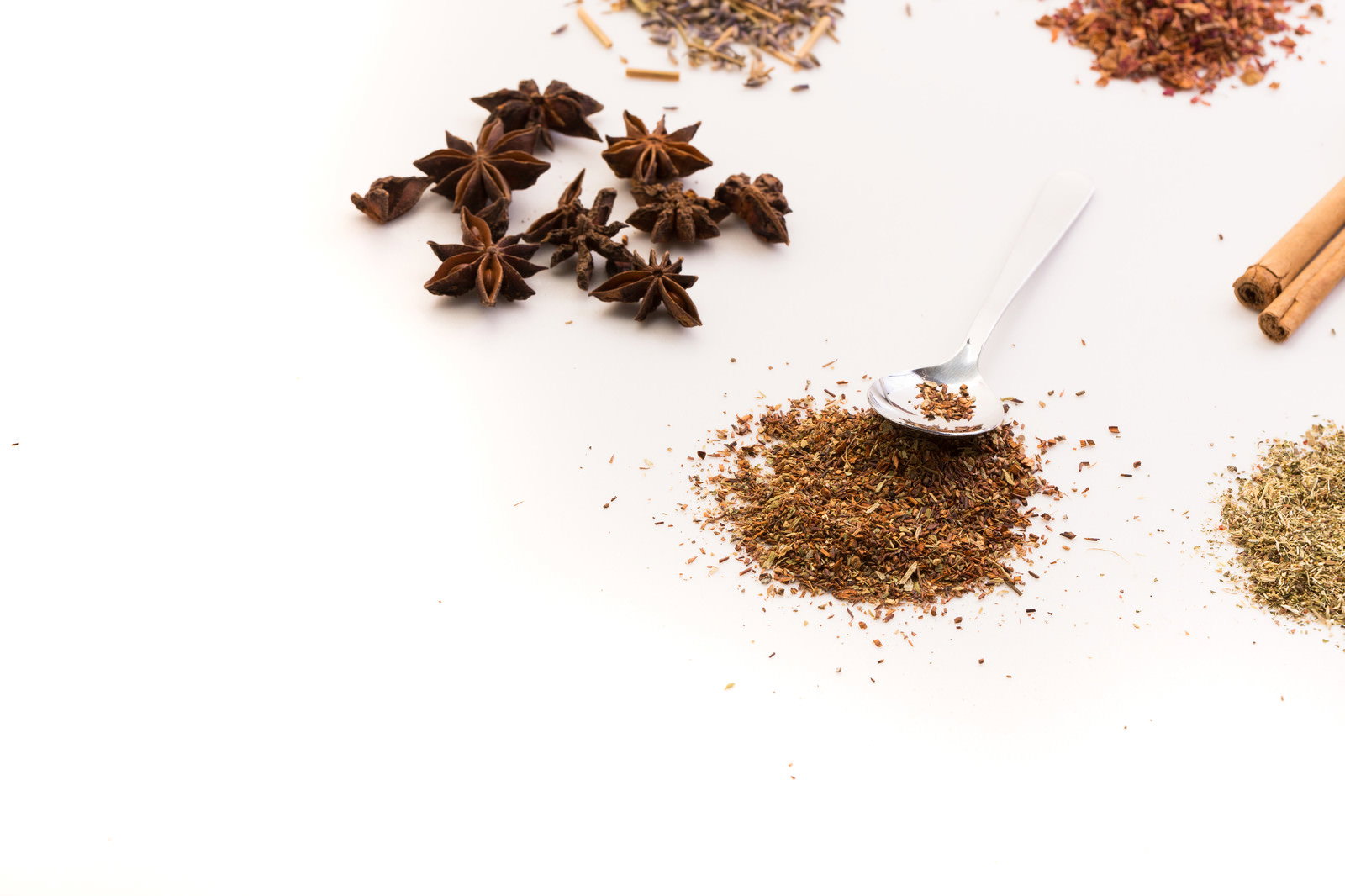 白い背景に配置された八角の実と茶色い粉末状の漢方薬