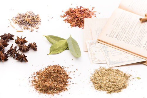 乾燥ハーブと漢方薬の粉末が並ぶ古書とのスタイリング