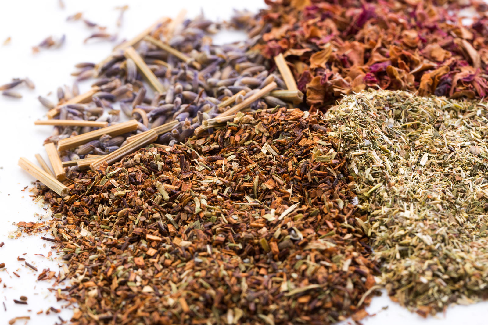白い背景に散らばった茶色と緑色の乾燥ハーブ