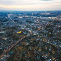 上空から撮影した夕暮れの高速道路と街並みの写真