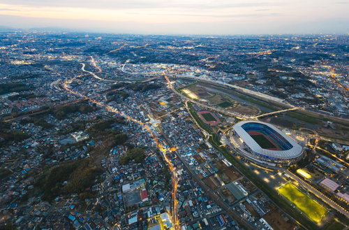 ヘリ空撮で捉えた日産スタジアム上空の夕暮れ景観