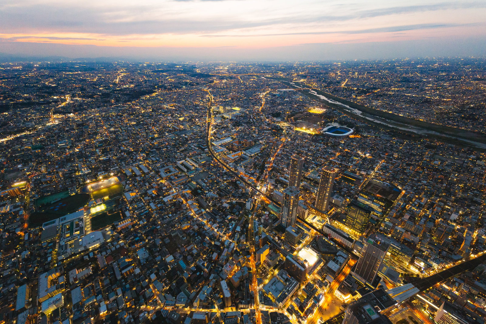 夕暮れ時の武蔵小杉タワーマンション群を空撮した都市景観