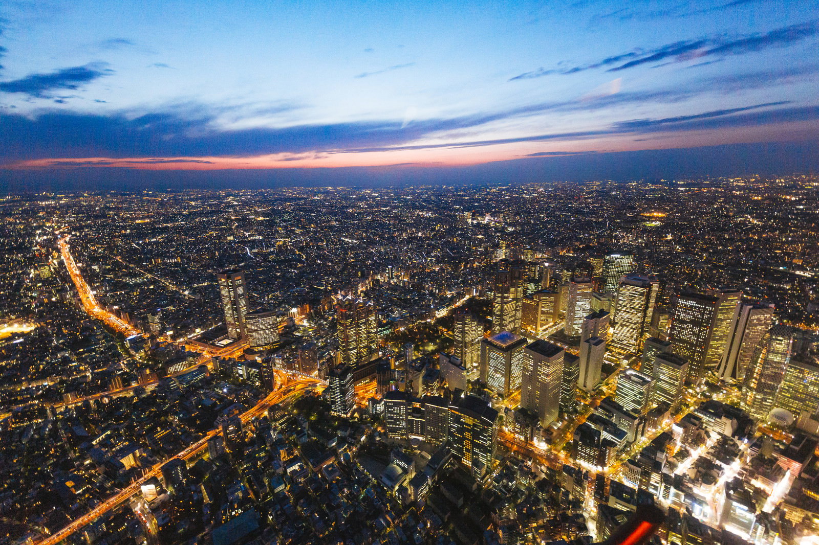 夕暮れ時の新宿ビル群を上空から撮影した夜景