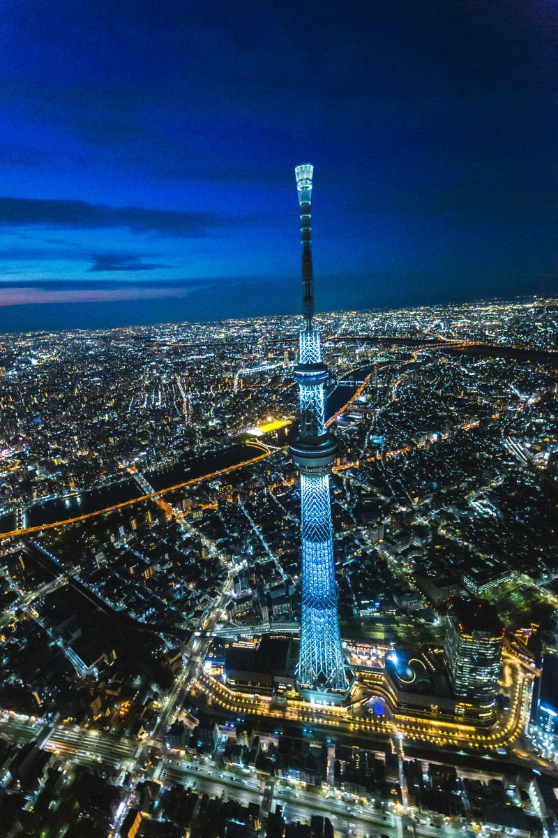 夜空に聳える東京スカイツリーと光る街並みの空撮夜景