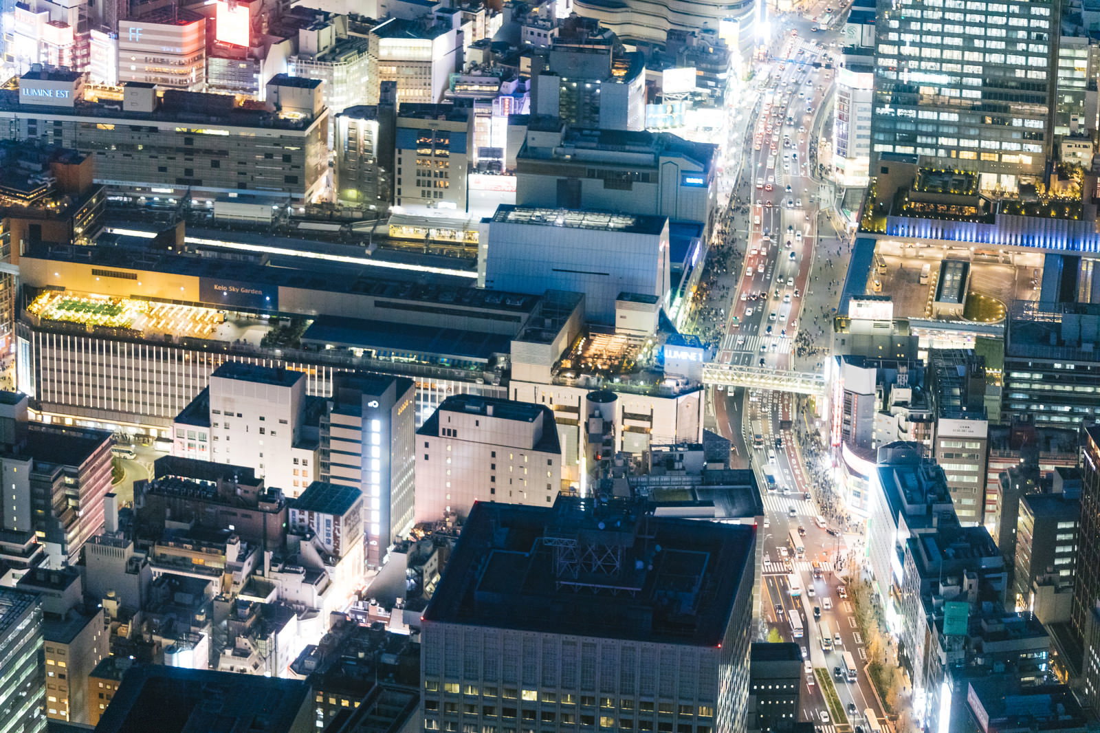 渋谷駅周辺の高層ビル群が夜の光に照らされた空撮夜景