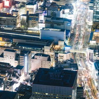 渋谷駅周辺の高層ビル群を映す空撮夜景の写真