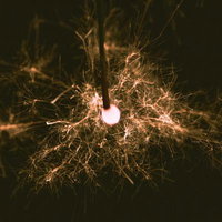 線香花火の火花が夜空に散る夏の夜の手持ち花火の写真