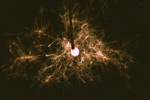 線香花火の火花が夜空に散る夏の夜の手持ち花火