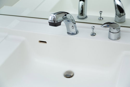 白い洗面台に設置されたシルバーの蛇口とシャワーヘッド