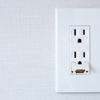 白い壁に設置された一般的な家庭用コンセント差込口の写真