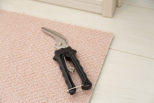 ピンク色のカーペットタイルとカット用はさみ