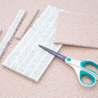 細かくカットされたタイルカーペットとはさみの写真