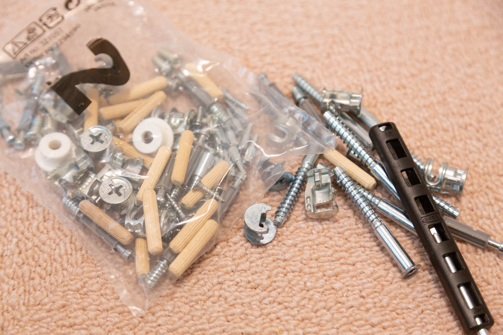 透明な袋に入ったIKEAの家具組み立て用ネジと六角レンチなどの部品