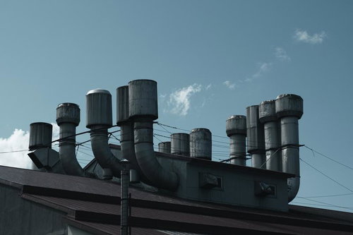 工場の複数の煙突と排気口から排出される排気