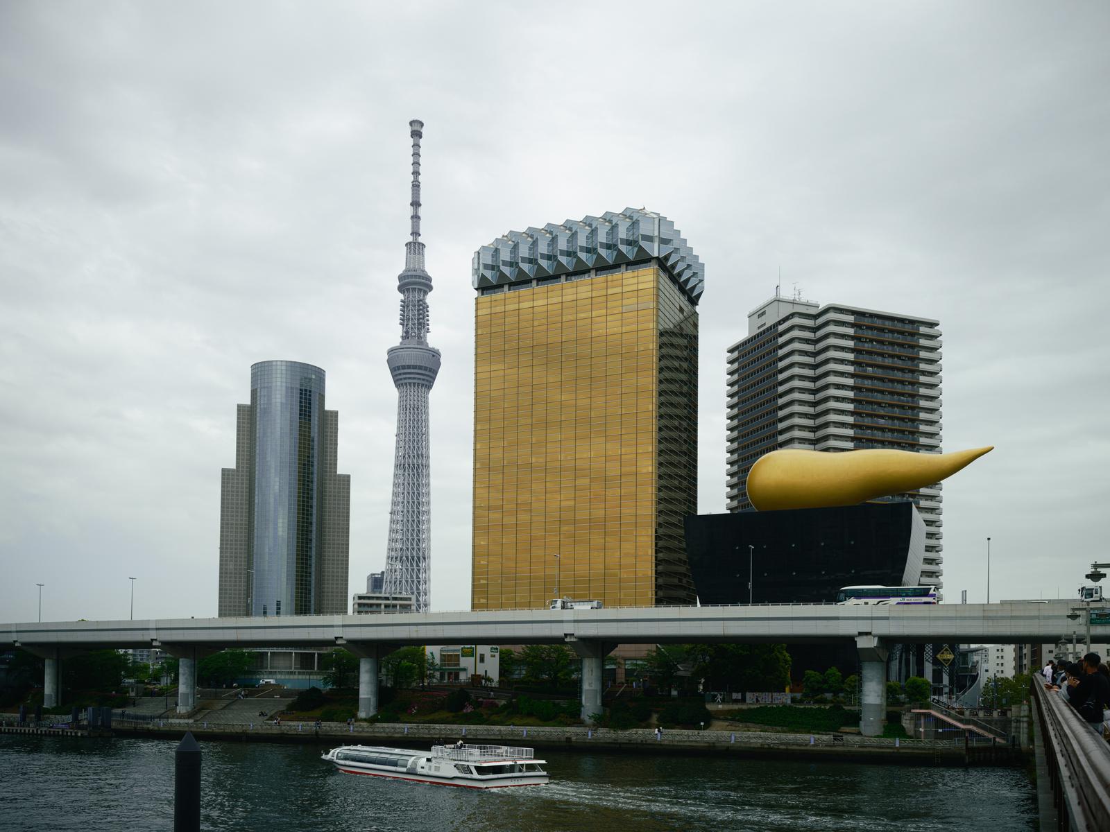 曇り空の下にそびえるスカイツリーと黄金色のアサヒビールタワー