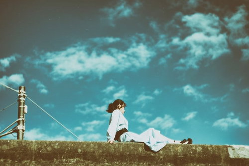 埠頭に座る白いワンピースの女性 港の青空