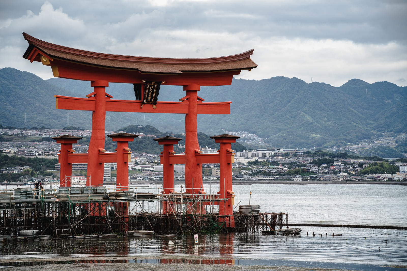 保全修理中の厳島神社大鳥居と海、背景の山々