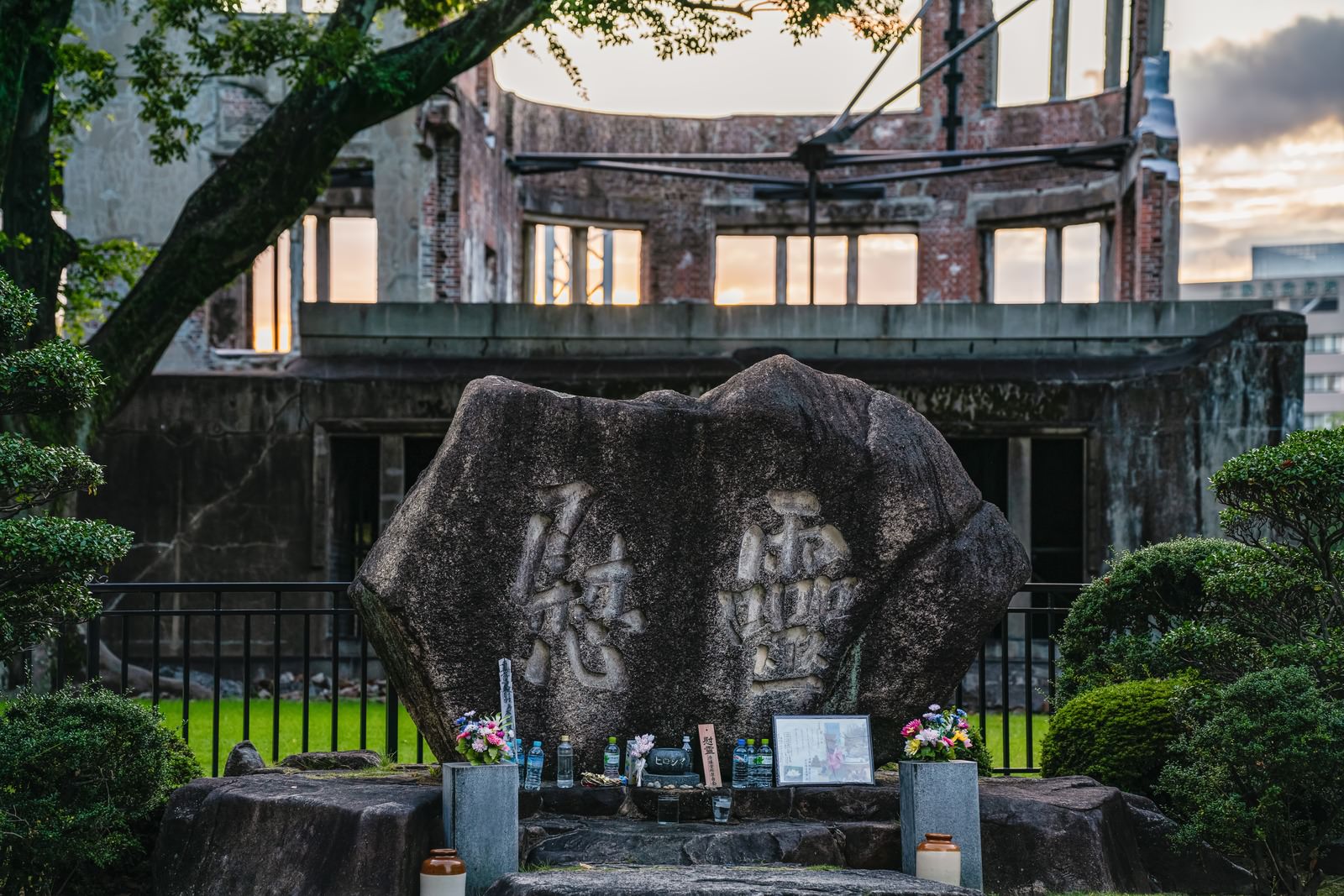 広島原爆ドーム近くの慰霊碑、石造の碑の前に供花が置かれている