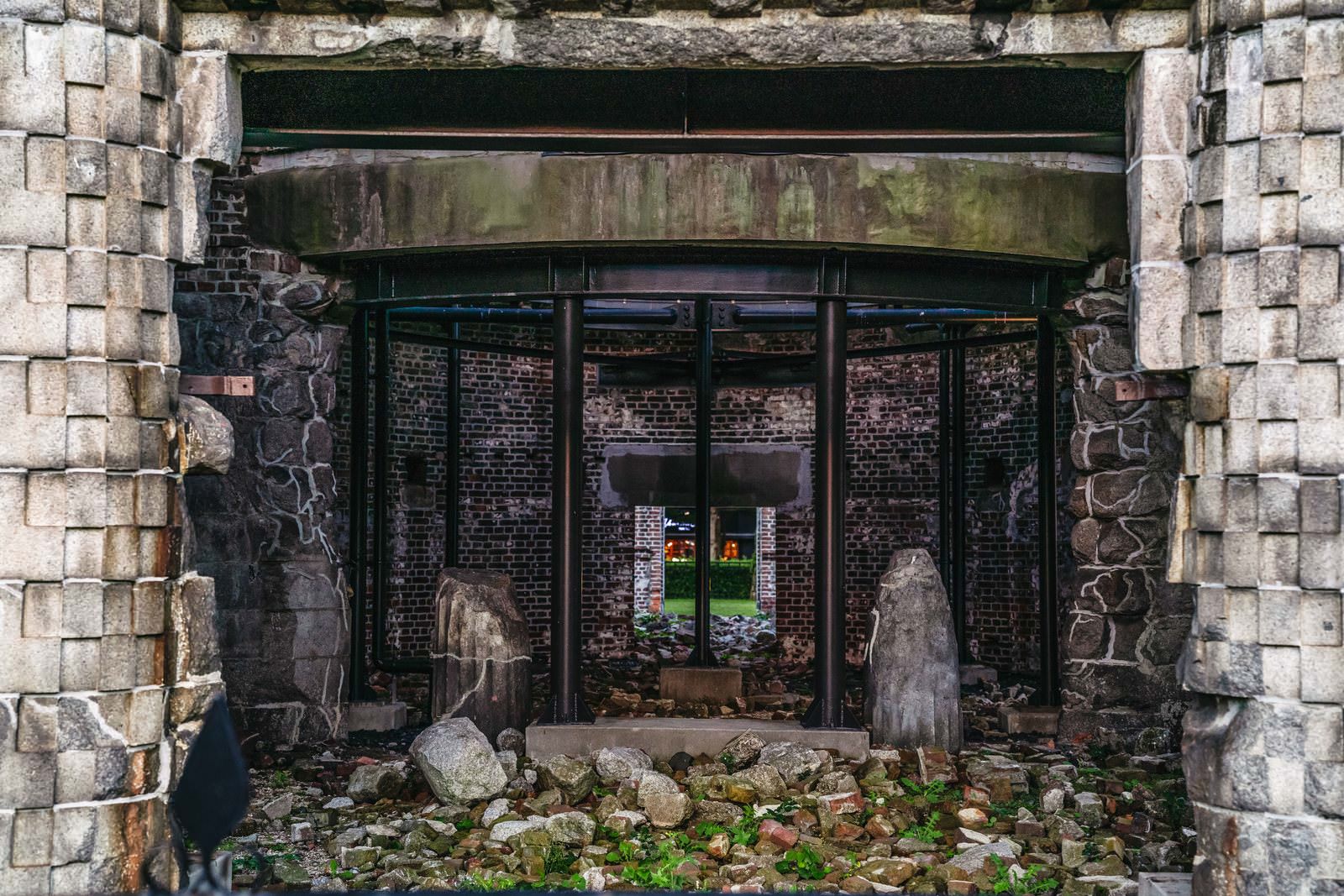 原爆ドームの出入口。石造の枠組みに囲まれ、奥に苔むしたレンガ壁が見える