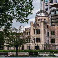 近代高層ビルに囲まれて立つ原爆ドーム、広島平和記念公園の写真