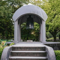 緑に囲まれた平和の鐘と慰霊施設の鐘楼の写真