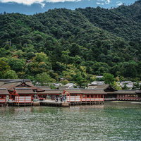 広島の厳島神社、海に面した朱色の建物と境内の風景の写真