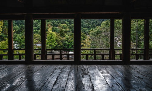 広島の神社境内で木製柱越しに望む緑豊かな木々の風景