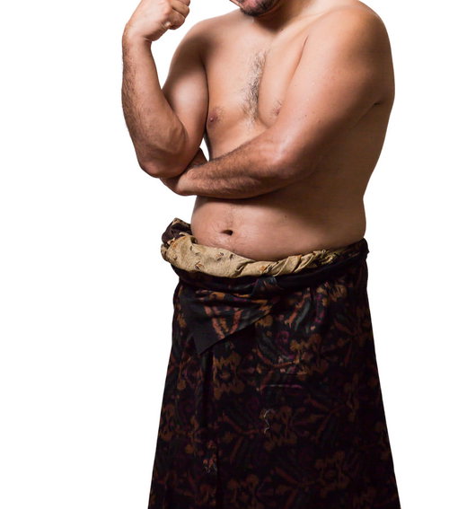 メタボ腹を隠そうとする民族衣装の男性のボディ