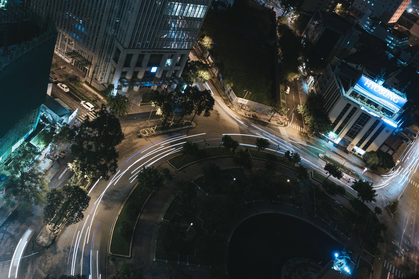 夜の都市部で車のライトが描く光の軌跡と高層ビルの夜景