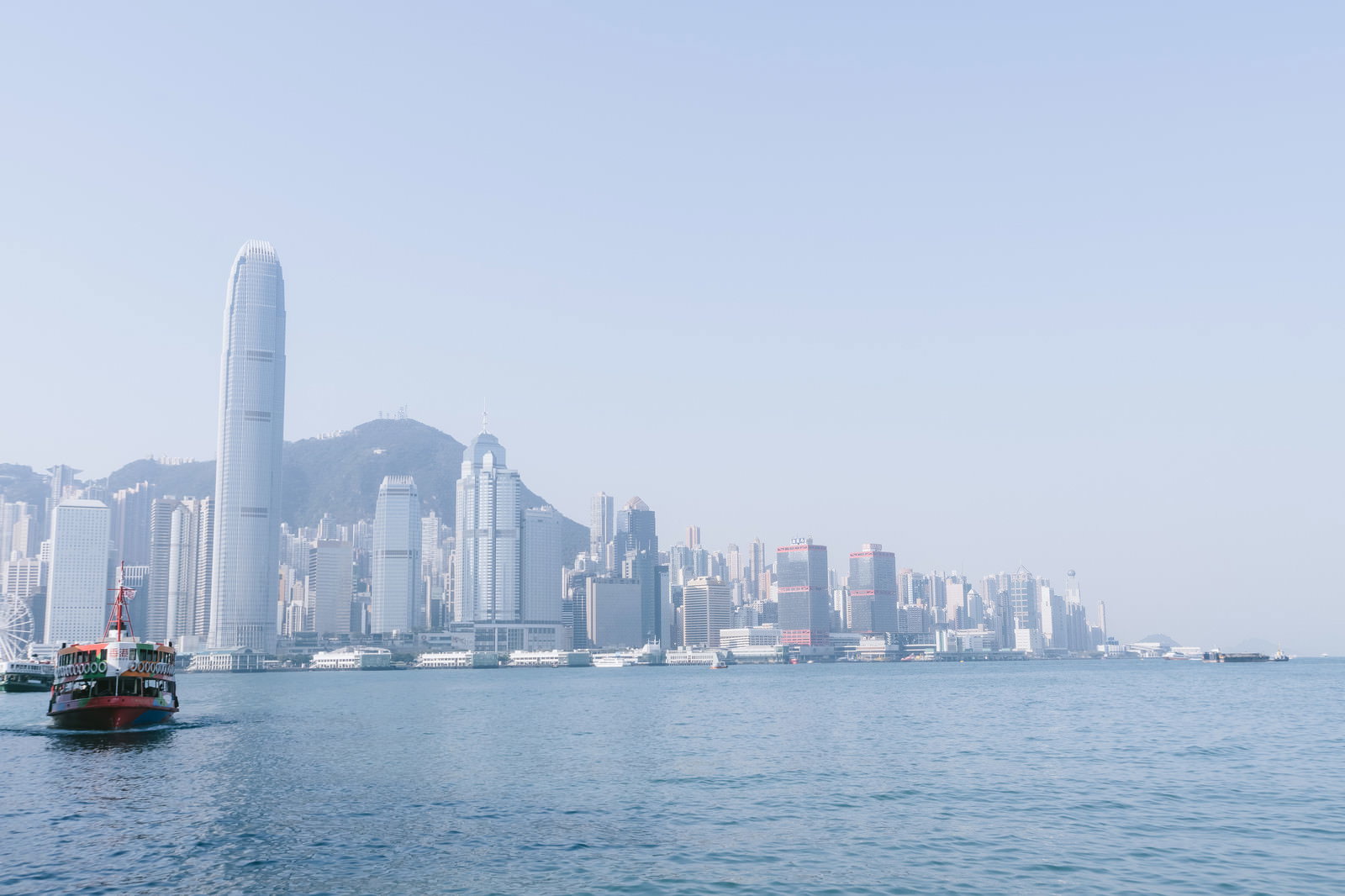香港の港湾に浮かぶフェリーと高層ビル群