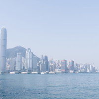 香港の港湾に浮かぶスターフェリーと高層ビル群の写真