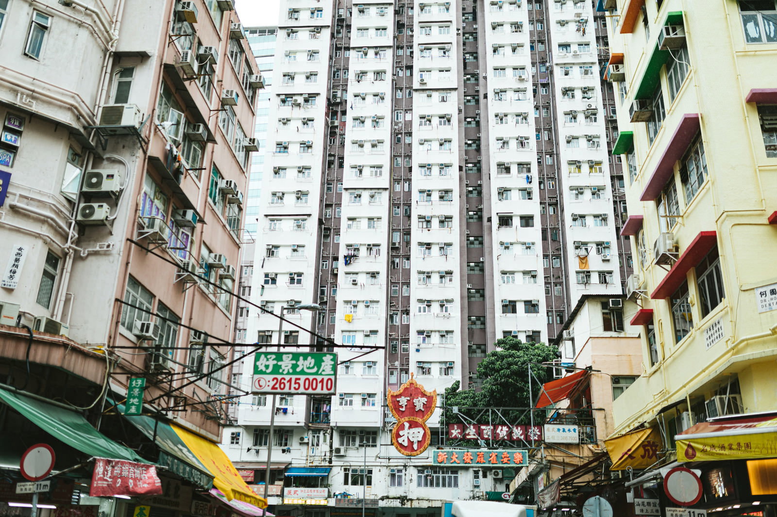 香港の密集した高層マンション群と商店街の風景