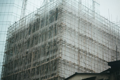 高層ビルも竹の足場で囲む香港の建設現場で働く作業員たち