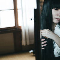 和室の鏡の前で黒髪を櫛でとく日本人女性の昭和レトロな姿の写真