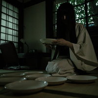 古民家の畳で皿の枚数を数え始める黒髪女性の写真