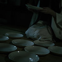 暗闇で皿を数える幽霊のような女性 - 皿屋敷の怪談表現の写真