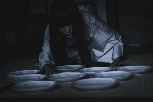 深夜の棚卸し作業で一枚合わない白い皿を数える女性