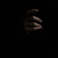 暗闇からスゥーっと現れる女性の手のホラー写真の写真