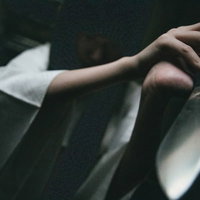 研ぎたての包丁を見せつけてくる白いシャツの手の写真