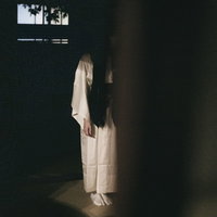 暗い和室に白装束の女性...の写真