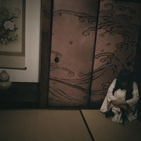 薄暗い和室で体育座りをする孤独な座敷娘の心理描写の写真