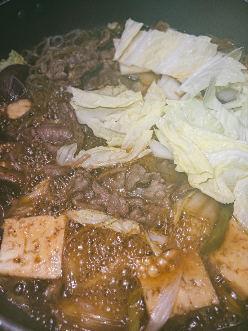 陶鍋に盛られた牛肉と白菜、豆腐、葱のすき焼き