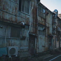 立ち並ぶ古いトタンの建物と路地の写真