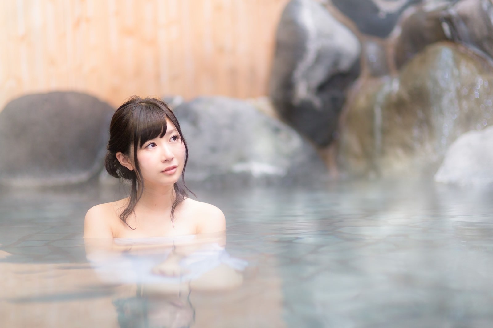 伊東温泉旅館の露天風呂で入浴する女性［モデル：モデルリリース］