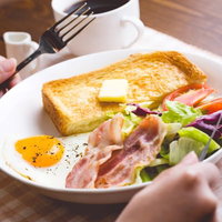 朝食のいただきます！バターとベーコンのトーストの写真
